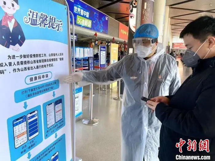 资料图:太原机场工作人员在各扫码点指导进出港旅客扫码和登录“健康码”二维码。山西太原武宿国际机场供图